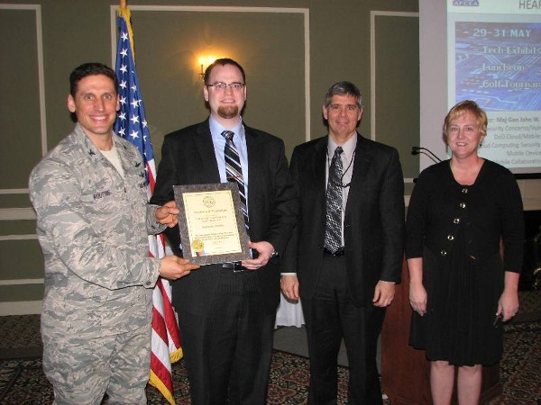 Col. Routsis (l) recognizes Strategic Professional Resources Incorporated as a new corporate sponsor. Company representatives on hand include Isaac R. Kleven (2nd from l), vice president and general manager; Michael Vaughn, U.S. Strategic Command Program lead; and Wendy Richey, corporate liaison.